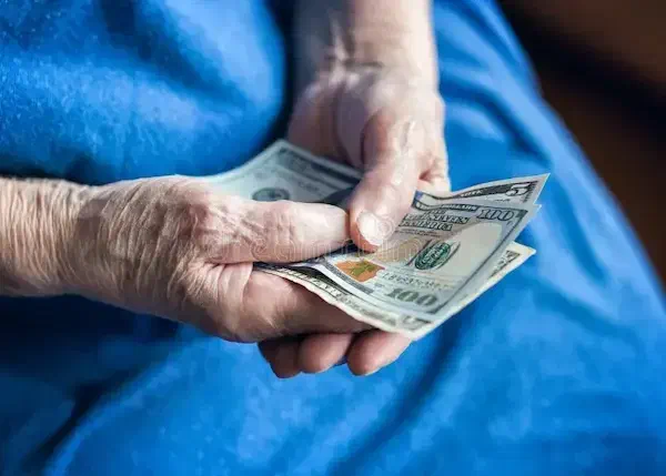 Una persona mayor cuenta billetes.