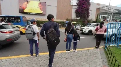 Una familia camina por una calle comercial.