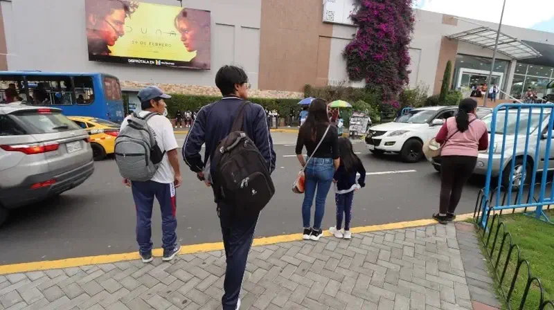 Una familia camina por una calle comercial.