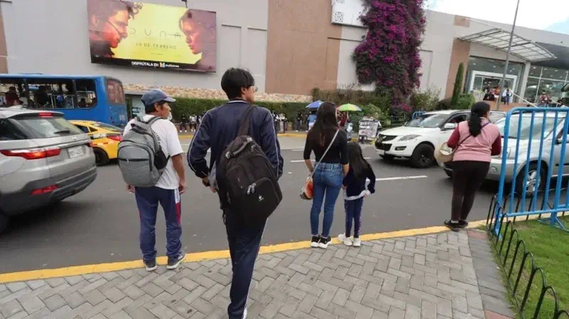 Una familia camina por una calle comercial.