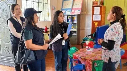 Encuestadoras del INEC entrevistan a una comerciante en un local.