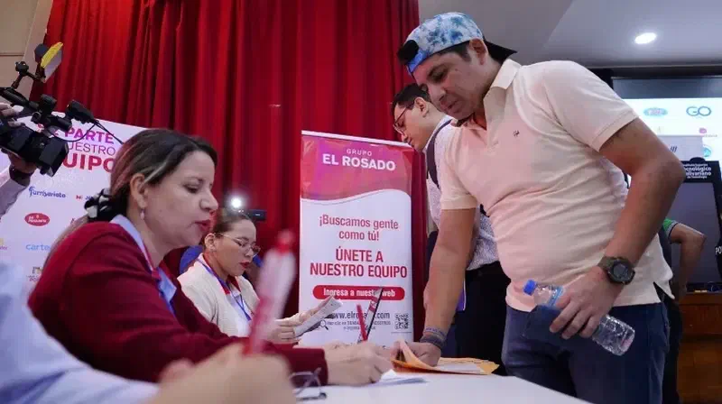 Un hombre recibe información en una feria de empleo.
